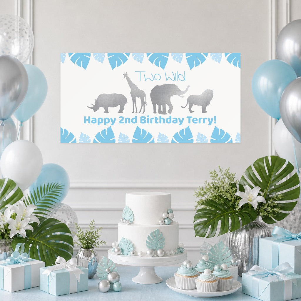 Blue Safari Two Wild second birthday decorations with Terry's original personalised animal banner, a leaf-decorated cake, cupcakes, blue and silver balloons and matching gifts.