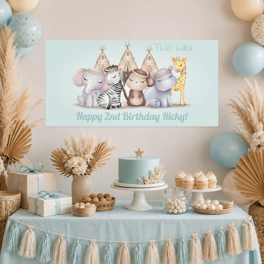 Boys Boho Jungle Two Wild second birthday decorations with Ricky's original personalised animal banner, a aqua blue cake, cupcakes, balloons and dried flowers.