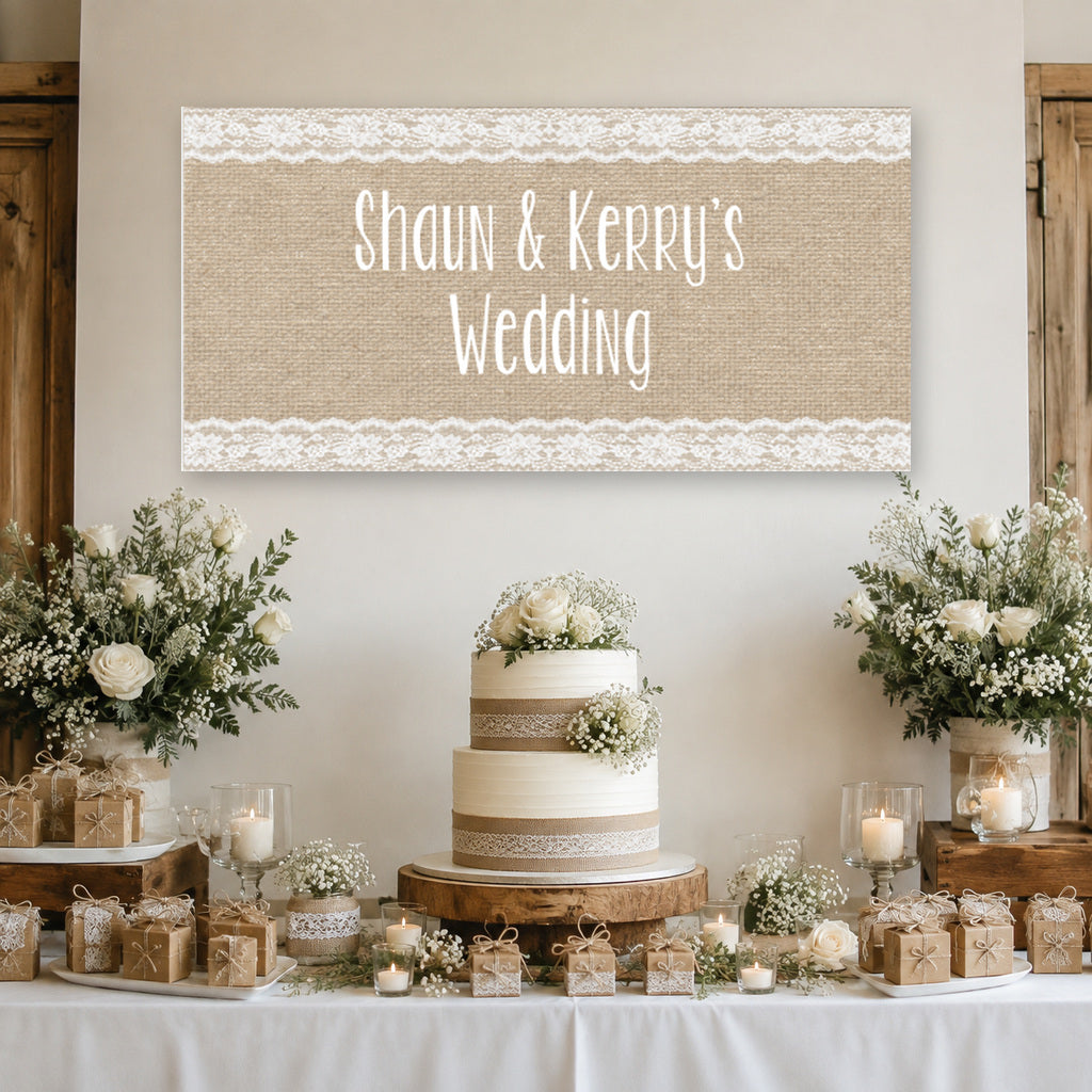 Burlap and lace wedding dessert table with Shaun and Kerry's personalised banner, tiered white cake, flowers, candles and rustic decorations.