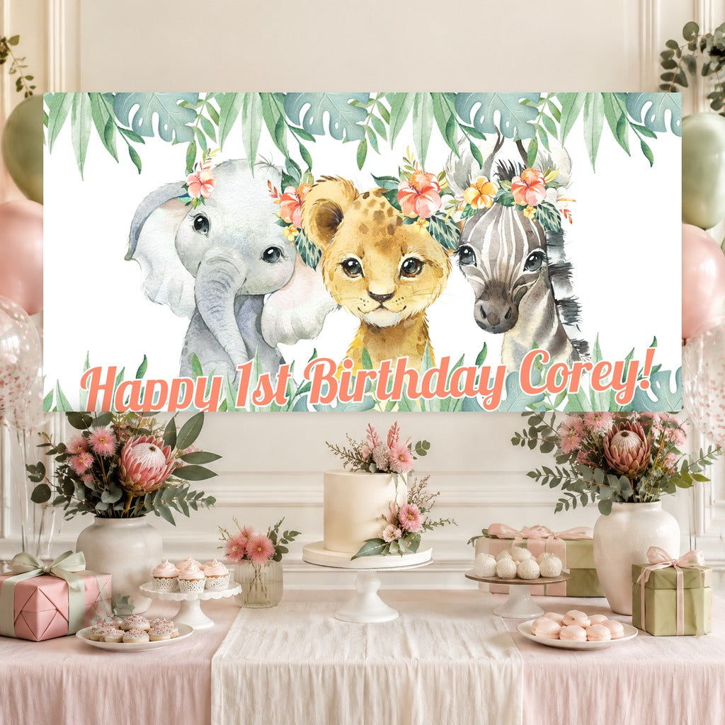 Floral African animals birthday dessert table with Corey's personalised banner, cake, balloons and tropical greenery.