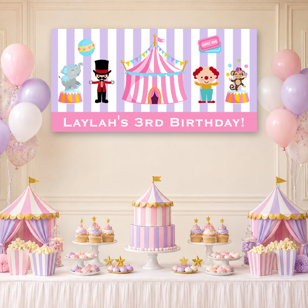 Pink and purple carnival birthday dessert table with Laylah's personalised banner, circus tent cake, balloons and matching decorations.