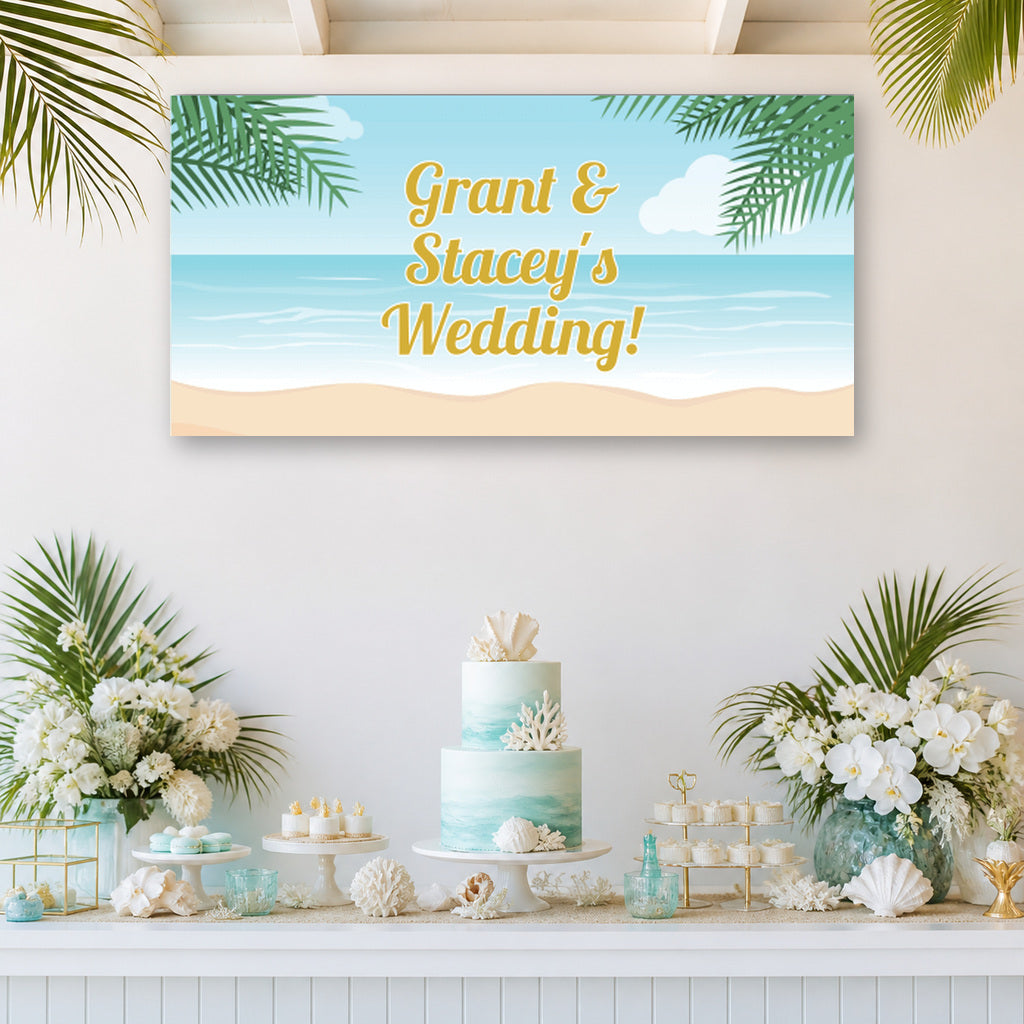Sandy tropical beach wedding dessert table with Grant and Stacey's personalised banner, ocean-blue cake, palm leaves, shells and white flowers.