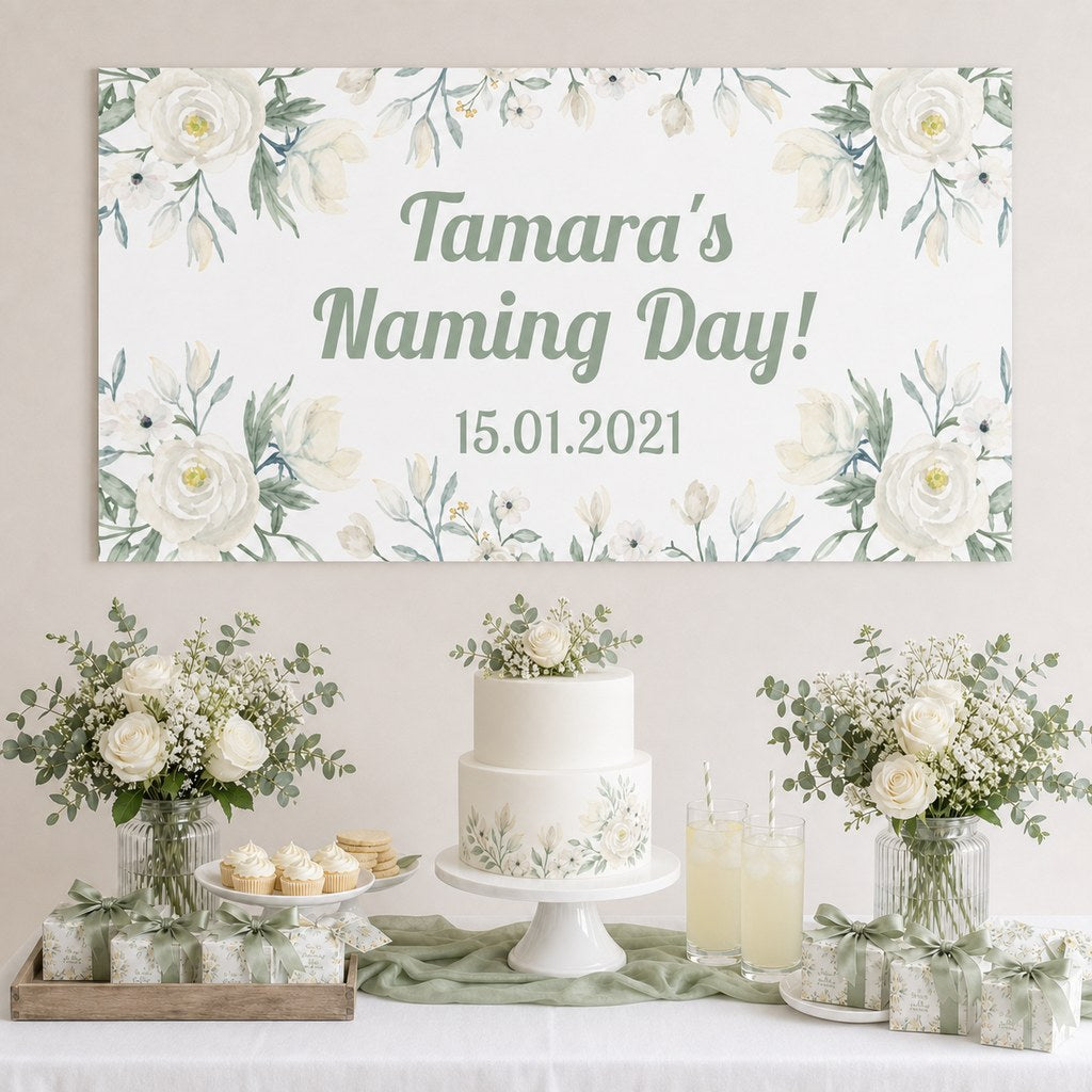 White Floral Naming Day Decorations with a personalised banner, coordinated cake, white roses and sage foliage.