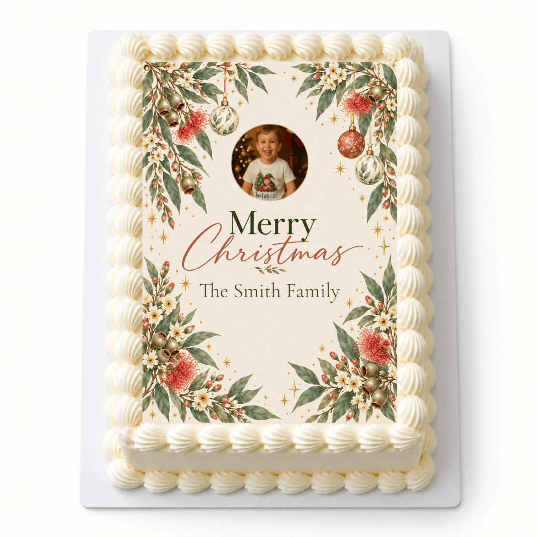 Aussie Botanicals Christmas A4 icing sheet with a child's photo and family name, framed by eucalyptus and baubles on a rectangular cake.