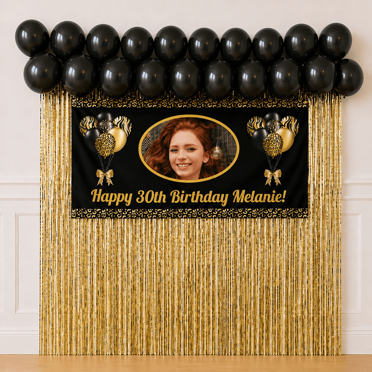 Black and gold personalised party package with photo banner, black balloons and gold foil curtains