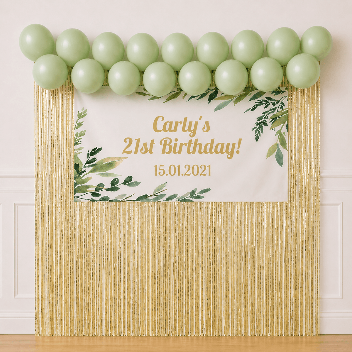 Personalised eucalyptus leaves birthday banner with pastel green balloon garland and gold foil backdrop for wholesale party packages