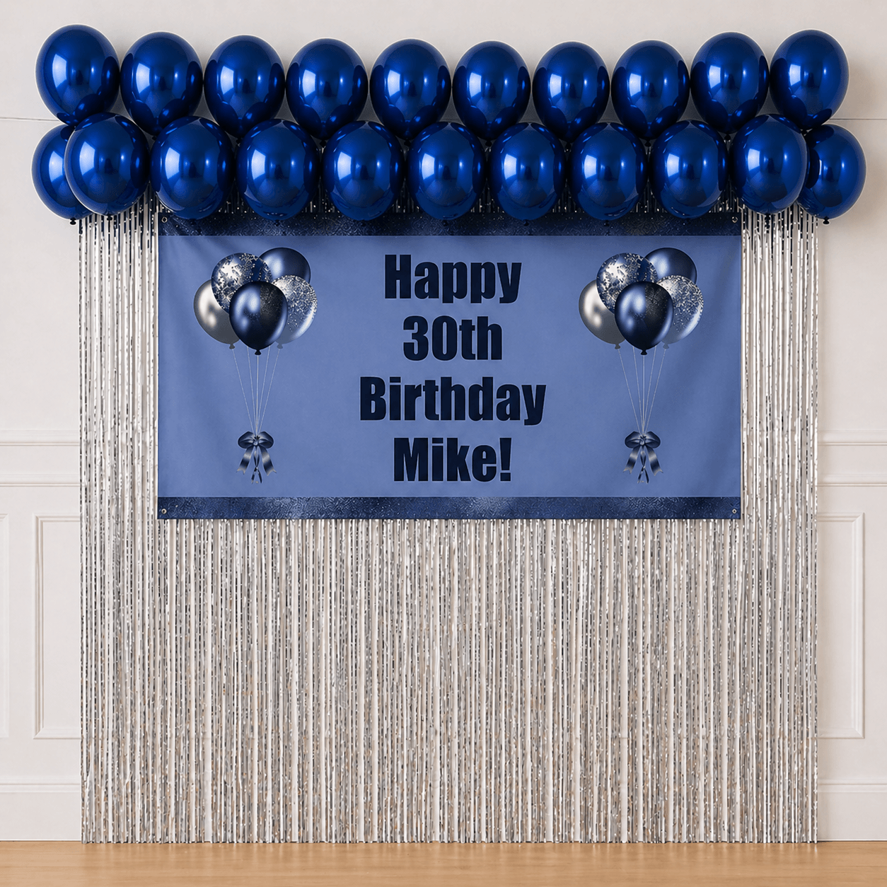 Personalised navy blue celebration party package with custom text banner, sapphire blue balloons and silver foil fringe curtains displayed as a completed party setup