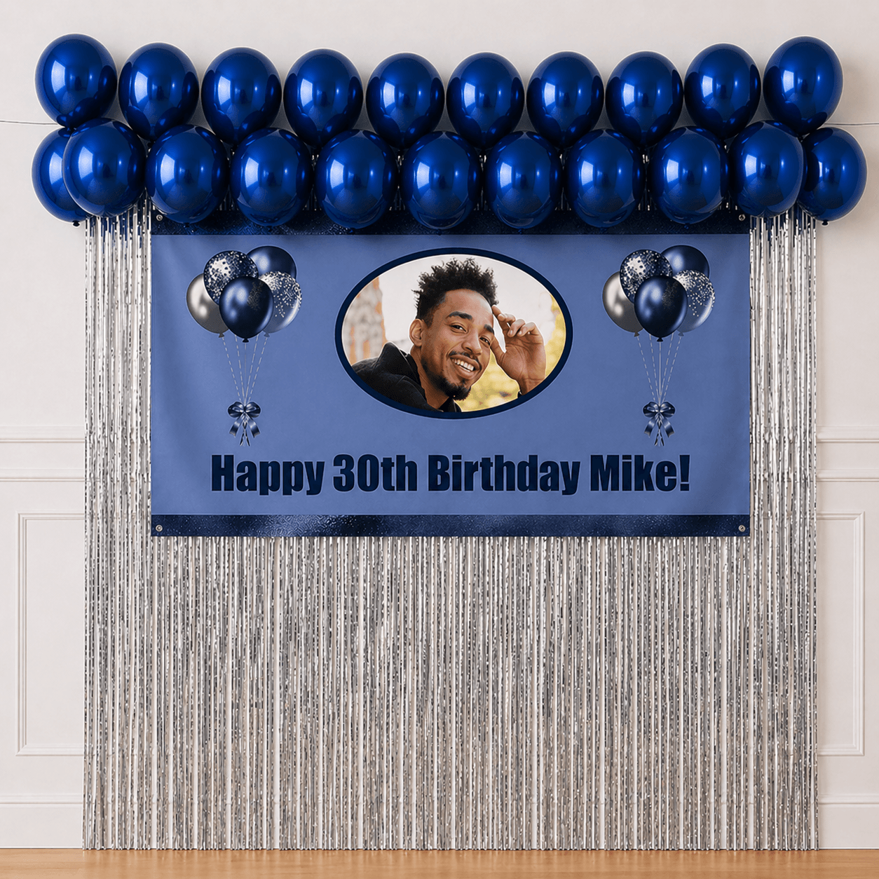 Personalised navy blue celebration party package with photo banner, sapphire blue balloons and silver foil fringe curtains displayed as a completed party setup