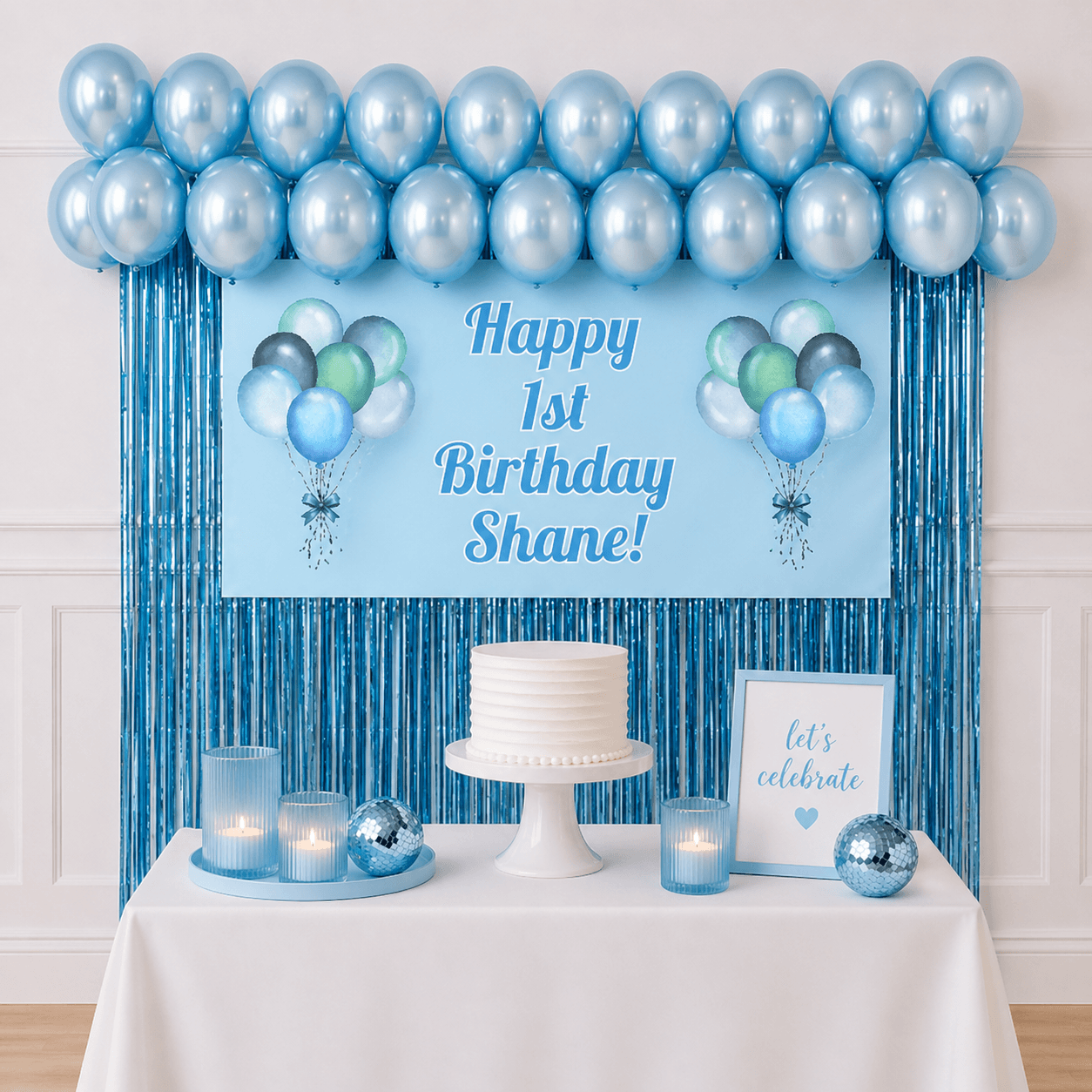 Personalised pastel blue celebration party package with custom text banner, pearl blue balloons and blue foil fringe curtains displayed as a completed party setup