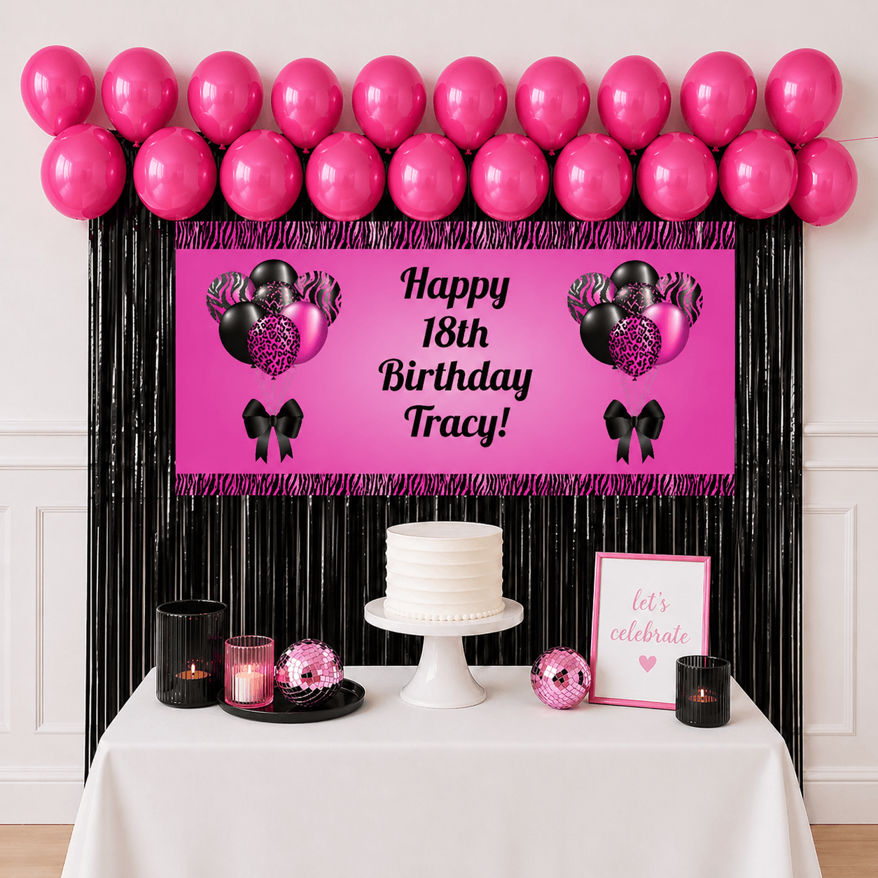 Personalised pink and black celebration party package with custom text banner, hot pink balloons and black foil fringe curtains displayed as a completed party setup